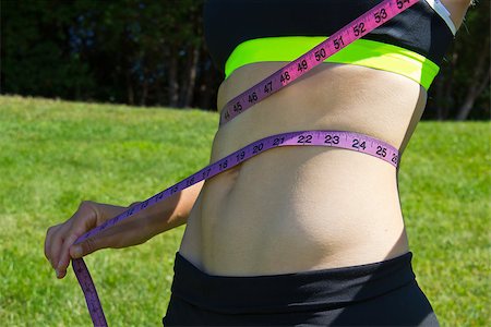 Fit woman measuring her weight loss with a measuring tape Photographie de stock - Aubaine LD & Abonnement, Code: 400-07254444