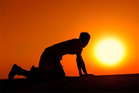 Tired and weaken man on all fours with gold sunset sun disk on background Stock Photo - Budget Royalty-Free & Subscription, Code: 400-07254498