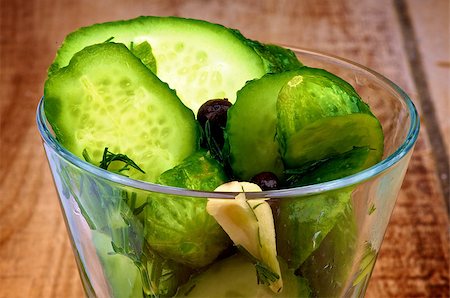 pickling gherkin - Appetizer with Slices of Delicious Pickled Cucumbers in Brine of Garlic, Dill, Parsley and Black Peppercorn in Glass Dish closeup on Wooden background Stock Photo - Budget Royalty-Free & Subscription, Code: 400-07254890