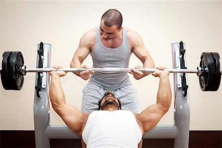 fair - A handsome young muscular sports man doing bench press with a little help Photographie de stock - Aubaine LD & Abonnement, Code: 400-07255279