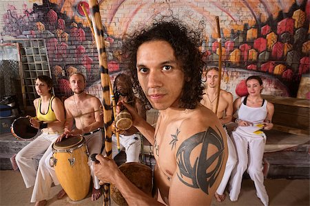 Handsome Latino capoeira expert with tattoo and musical instrument Foto de stock - Super Valor sin royalties y Suscripción, Código: 400-07256242