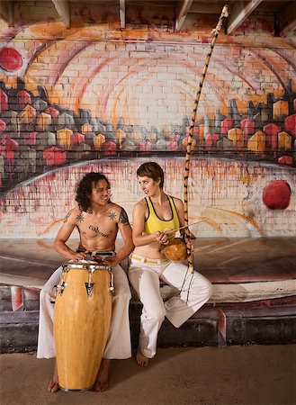 Cute mixed couple in capoeira clothing playing African music Foto de stock - Super Valor sin royalties y Suscripción, Código: 400-07256251