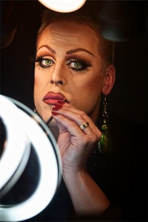 simsearch:400-07261849,k - Serious Caucasian drag queen using lipstick Fotografie stock - Microstock e Abbonamento, Codice: 400-07256253
