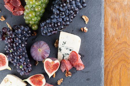 Slate board with blue cheese, blue and green grapes, figs, walnuts and salami Stock Photo - Budget Royalty-Free & Subscription, Code: 400-07256461