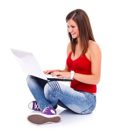 Pretty smiling brunette woman sits on the floor surfing on the internet using a laptop. White background. Foto de stock - Royalty-Free Super Valor e Assinatura, Número: 400-07257202