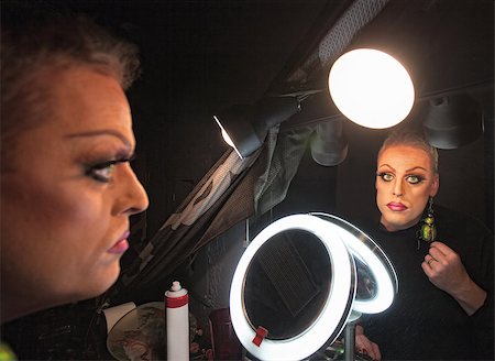 simsearch:400-07261849,k - Serious drag queen in front of mirror with lamp Fotografie stock - Microstock e Abbonamento, Codice: 400-07259423