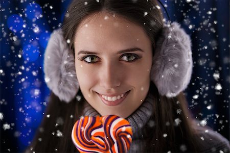 Beautiful girl holding a lollypop with snow falling around her. Stock Photo - Budget Royalty-Free & Subscription, Code: 400-07251554