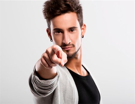 Handsome young man looking and pointing to the camera, over a gray background Stock Photo - Budget Royalty-Free & Subscription, Code: 400-07252319