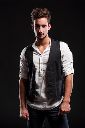 Studio portrait of a handsome and fashion young man, posing over a dark background Stock Photo - Budget Royalty-Free & Subscription, Code: 400-07252325