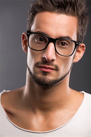 Casual portrait of a hansome young man wearing glasses, looking to the camera Stock Photo - Budget Royalty-Free & Subscription, Code: 400-07252331