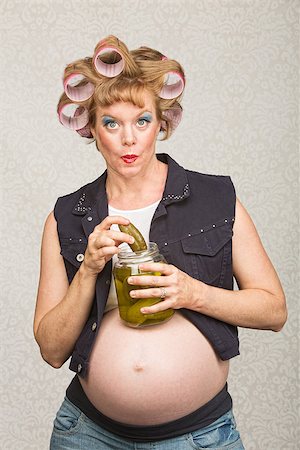 simsearch:400-07252384,k - Pregnant white woman in curlers with jar of pickles Photographie de stock - Aubaine LD & Abonnement, Code: 400-07252394