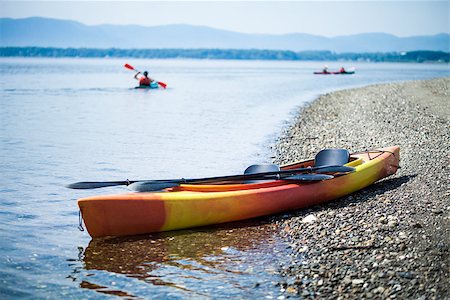 simsearch:400-05362222,k - Orange and Yellow Kayak on the Sea Shore During a beautiful Day of Summer with Unrecognizable People Kayaking in the Background Stock Photo - Budget Royalty-Free & Subscription, Code: 400-07253237