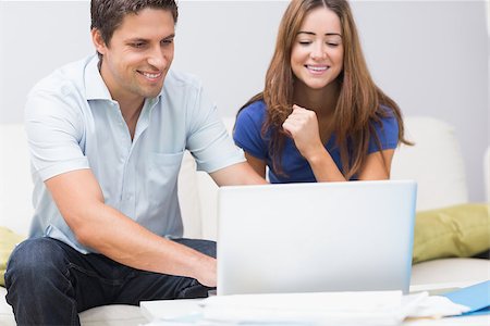 simsearch:400-07274613,k - Cute young couple sitting on sofa and using laptop at home Stock Photo - Budget Royalty-Free & Subscription, Code: 400-07266764