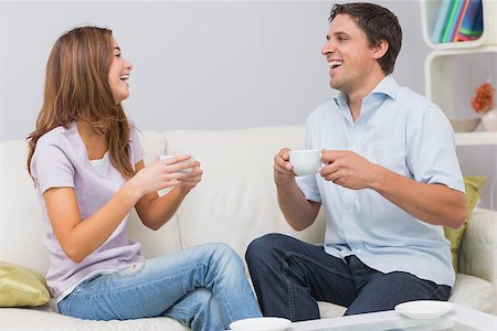 simsearch:6109-07601570,k - Cheerful young couple sitting on sofa and enjoying their tea at home Stockbilder - Microstock & Abonnement, Bildnummer: 400-07266788