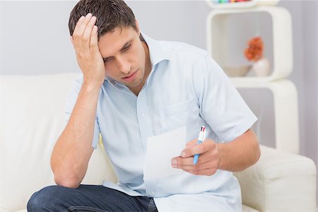 simsearch:6109-08390207,k - Worried young man paying his bills in the living room at home Foto de stock - Super Valor sin royalties y Suscripción, Código: 400-07266783