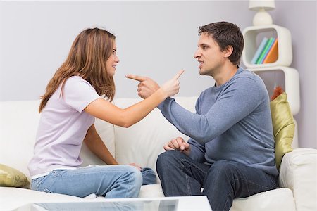 simsearch:400-06687238,k - Side view of an angry young couple having an argument in their living room at home Fotografie stock - Microstock e Abbonamento, Codice: 400-07266801