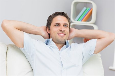 Thoughtful young man sitting with hands behind head in the living room at home Stock Photo - Budget Royalty-Free & Subscription, Code: 400-07266812