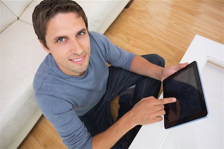 simsearch:400-06872352,k - Overhead portrait of a young man using digital tablet in living room at home Foto de stock - Royalty-Free Super Valor e Assinatura, Número: 400-07266880