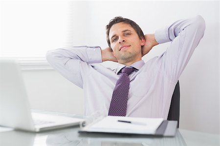 Portrait of a relaxed businessman sitting with hands behind head in a bright office Stock Photo - Budget Royalty-Free & Subscription, Code: 400-07266938