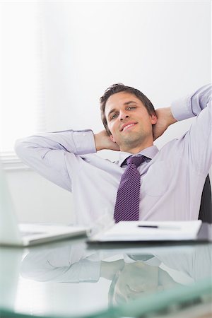 Portrait of a relaxed businessman sitting with hands behind head in a bright office Stock Photo - Budget Royalty-Free & Subscription, Code: 400-07266939