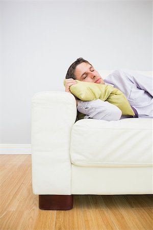 simsearch:6108-06167292,k - Tired young businessman sleeping on sofa in the living room at home Stockbilder - Microstock & Abonnement, Bildnummer: 400-07266930