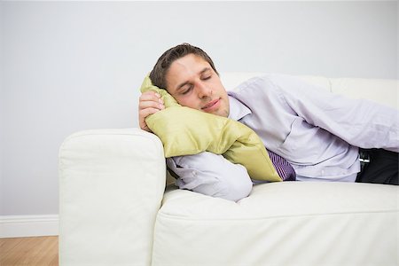 simsearch:400-07274613,k - Tired young businessman sleeping on sofa in the living room at home Stock Photo - Budget Royalty-Free & Subscription, Code: 400-07266933