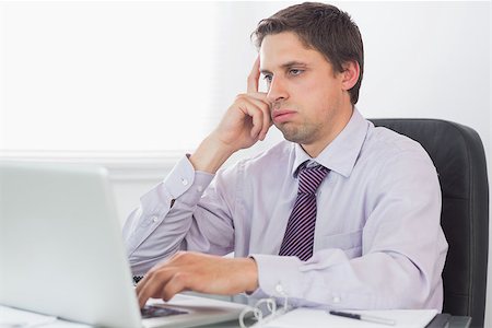 simsearch:400-07931035,k - Young worried businessman using laptop at desk in the office Stock Photo - Budget Royalty-Free & Subscription, Code: 400-07266944