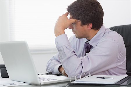 simsearch:400-07931035,k - Young worried businessman with laptop sitting at desk in the office Stock Photo - Budget Royalty-Free & Subscription, Code: 400-07266945