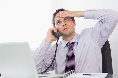 simsearch:400-07275251,k - Worried businessman on call in front of computer at office desk Stock Photo - Budget Royalty-Free & Subscription, Code: 400-07266940