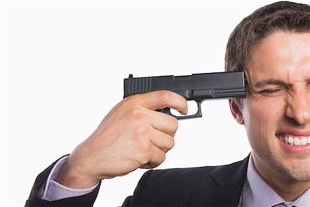 shooting the head with the hand - Close-up of a young businessman holding a gun to head against white background Stock Photo - Budget Royalty-Free & Subscription, Code: 400-07266982