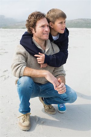 simsearch:400-07267308,k - Casual young man and smiling son relaxing at the beach Fotografie stock - Microstock e Abbonamento, Codice: 400-07267114