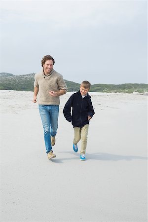 simsearch:400-07267308,k - Full length of a young man and son jogging at the beach Fotografie stock - Microstock e Abbonamento, Codice: 400-07267116