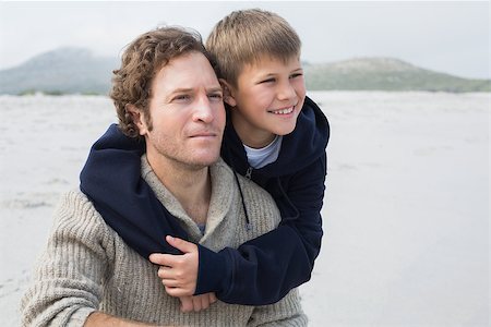 simsearch:400-07267308,k - Casual young man and smiling son relaxing at the beach Fotografie stock - Microstock e Abbonamento, Codice: 400-07267112