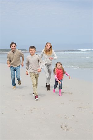 simsearch:400-07267308,k - Full length portrait of a happy family of four running at the beach Fotografie stock - Microstock e Abbonamento, Codice: 400-07267206