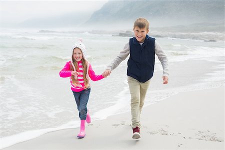 simsearch:400-07267308,k - Full length of a happy brother and sister walking hand in hand at the beach Fotografie stock - Microstock e Abbonamento, Codice: 400-07267210