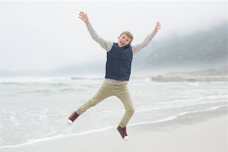 simsearch:400-07267308,k - Full length portrait of a casual young boy jumping at the beach Fotografie stock - Microstock e Abbonamento, Codice: 400-07267240