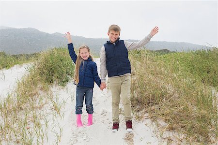 simsearch:400-07267308,k - Full length of a happy brother and sister standing hand in hand at the beach Fotografie stock - Microstock e Abbonamento, Codice: 400-07267278