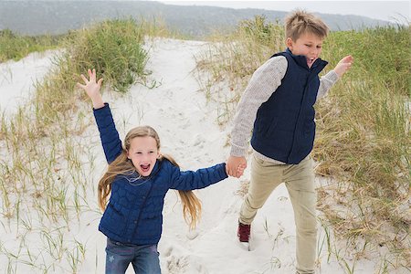 simsearch:400-07267308,k - Happy brother and sister running hand in hand at the beach Fotografie stock - Microstock e Abbonamento, Codice: 400-07267280