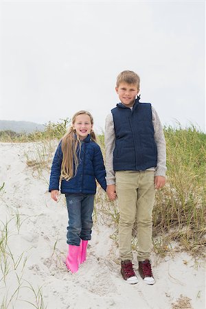 simsearch:400-07267308,k - Full length of a happy brother and sister standing hand in hand at the beach Fotografie stock - Microstock e Abbonamento, Codice: 400-07267283