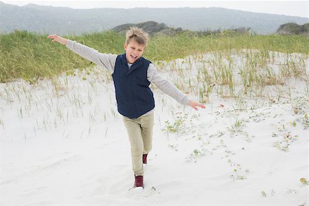 simsearch:400-07267308,k - Full length of a cheerful young boy running at the beach Fotografie stock - Microstock e Abbonamento, Codice: 400-07267295
