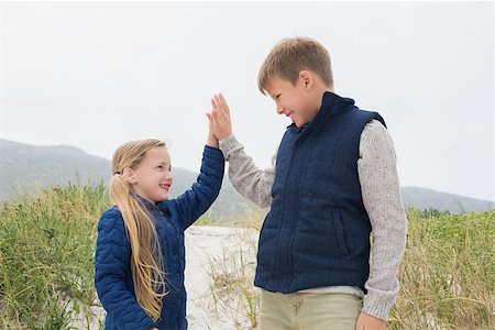 simsearch:400-07267308,k - Low angle view of a happy brother and sister standing at the beach Fotografie stock - Microstock e Abbonamento, Codice: 400-07267290