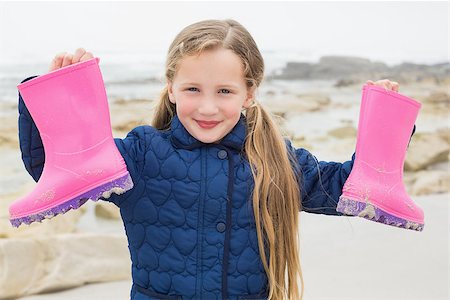 pink rain boots for girls - Portrait of a cute smiling young girl holding her wellington boots at the beach Stock Photo - Budget Royalty-Free & Subscription, Code: 400-07267350
