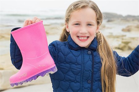 pink rain boots for girls - Portrait of a cute smiling young girl holding her wellington boot at the beach Stock Photo - Budget Royalty-Free & Subscription, Code: 400-07267351