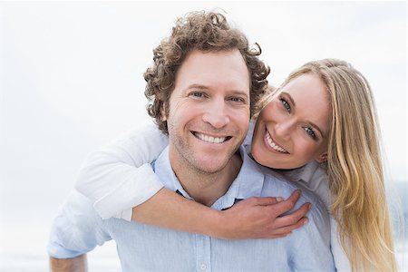 Portrait of a young man piggybacking beautiful woman at the beach Photographie de stock - Aubaine LD & Abonnement, Code: 400-07267447