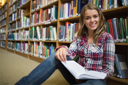 simsearch:400-07141917,k - Happy pretty student sitting on library floor reading book in college Stock Photo - Budget Royalty-Free & Subscription, Code: 400-07267490