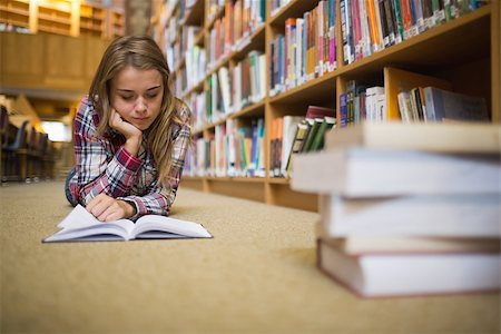 simsearch:400-07141917,k - Pretty focused student lying on library floor reading book in college Stock Photo - Budget Royalty-Free & Subscription, Code: 400-07267503