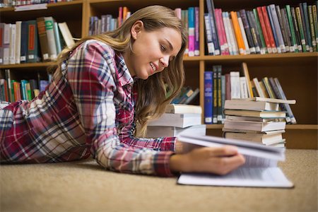 simsearch:400-07141917,k - Smiling student lying on library floor reading in college Stock Photo - Budget Royalty-Free & Subscription, Code: 400-07267529