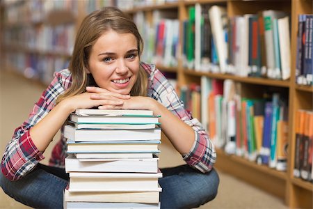 simsearch:400-07141917,k - Smiling student sitting on library floor leaning on pile of books in college Stock Photo - Budget Royalty-Free & Subscription, Code: 400-07267540