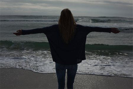 simsearch:6109-07496983,k - Silhouette rear view of a casual young woman with arms outstretched standing at the beach Stock Photo - Budget Royalty-Free & Subscription, Code: 400-07267587
