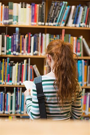 simsearch:400-07267769,k - Redhead student reading book from shelf standing in library at the university Stock Photo - Budget Royalty-Free & Subscription, Code: 400-07267626